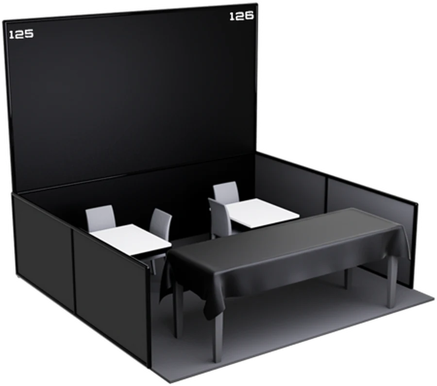 A trader stand at the show: panelled back and side walls, a dressed table and seating.