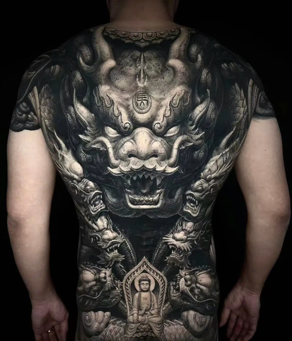 A back piece by Yue Heng: a guardian lion above a seated Buddha, flanked by dragons.